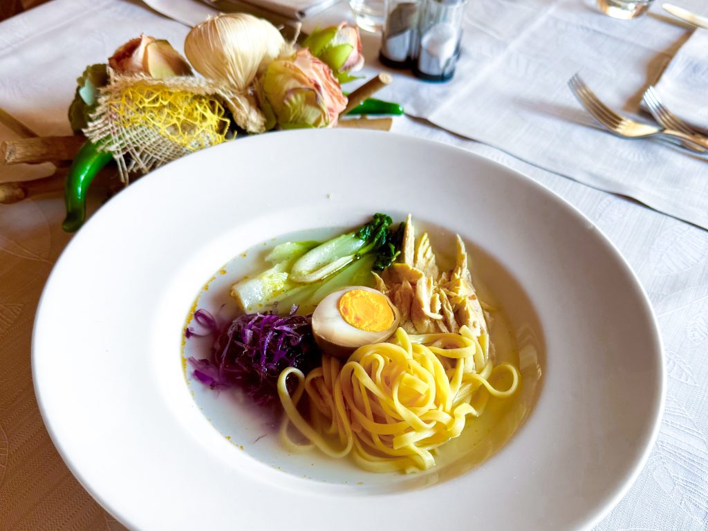 Zuppa di gallina padovana: ramen veneto, brodo di gallina, sfilacci di gallina, tagliolini all'uovo, bietina, uovo marinato alla soia, cipolotto, zenzero